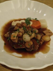 Confit beef chuck eye, Grand-Mère-style garnishes, served with a rich meat jus.
