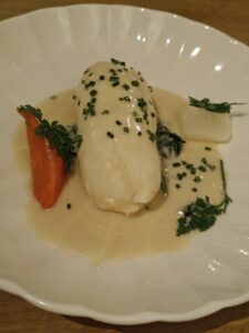 Pike quenelle, lemon beurre blanc with droplets of herb oils